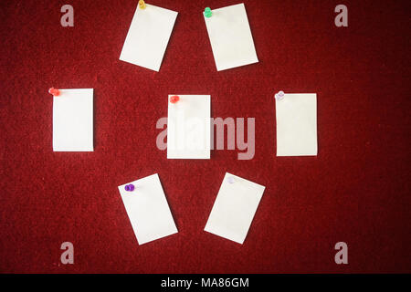 collection of note papers pinned on a red board ready for filling in quotes. Stock Photo