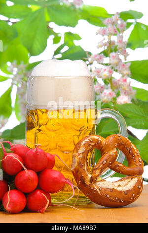 big glass filled with Bavarian lager beer and snack for beer garden Stock Photo
