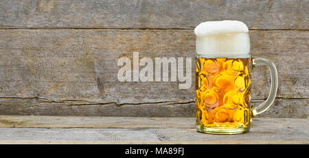 wide angle view to big glass filled with Bavarian lager beer on wooden plank with copy space Stock Photo