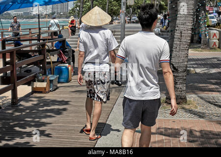 Chinese tourist wearing a traditional conical "coolie" hat Stock Photo