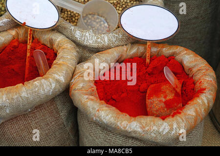 Close up several canvas bags of assorted spices, red paprika, white peppercorns, with copy space of blank price tags on retail display of market stall Stock Photo