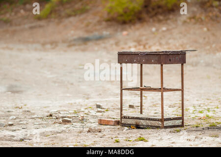 Rusty metal oven for barbecue stands on the beach Stock Photo