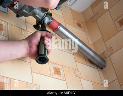 Drilling a large hole in the wall Stock Photo