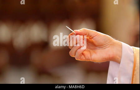 Priest gives holy communion to faithful and empty place for text Stock Photo