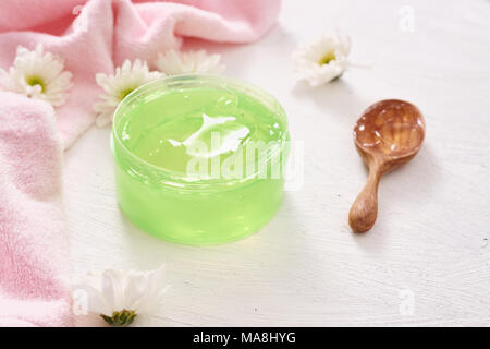 spa setting with cosmetic cream, gel, bath salt and fern leaves on white wooden table background Stock Photo