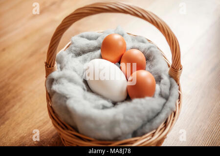 Goose egg and hens eggs, in an Easter basket. Photographed on a wooden floor. Stock Photo