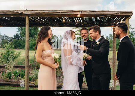 Groom lifting up bridal veil to kiss the bride. Newlywed couple about to kiss after the wedding ceremony Stock Photo