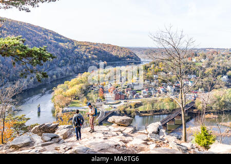 Harper's Ferry, USA - November 11, 2017: Overlook with hiker people, couple, colorful orange yellow foliage fall autumn forest with small village town Stock Photo