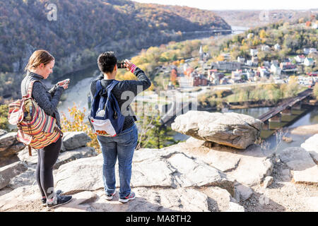 Harper's Ferry, USA - November 11, 2017: Overlook with hiker people, couple women, colorful orange yellow foliage fall autumn forest with small villag Stock Photo
