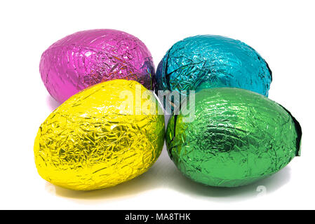 Four Colourful Foil Wrapped Easter Eggs on a plain white background Stock Photo
