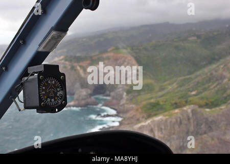 View from the Copilot's seat of a helicopter flying over the coat of the island of Maui in the Hawaiian Islands. Stock Photo