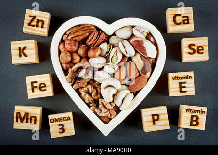 Microelements and vitamins in different types of nuts. Healthy food concept Stock Photo