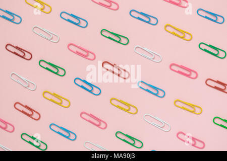 Decorative paper clips pattern on pastel pink background minimal creative concept. Stock Photo