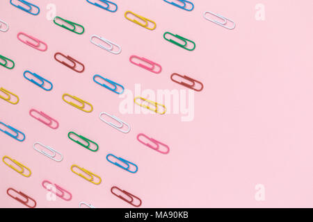 Decorative paper clips pattern on pastel pink background minimal creative concept. Space for copy. Stock Photo