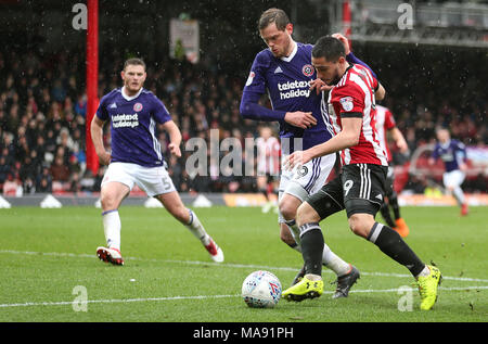 Brentford's Neal Maupay (centre) and Sheffield United's Leon Clarke (second left) battle for the ball during the Sky Bet Championship match at Griffin Park, London. Stock Photo