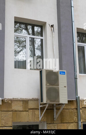 A Midea air conditioning unit on the outer wall of a residential  apartment block in Rila Village, southwestern Bulgaria. Stock Photo
