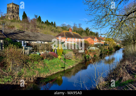 River Salwarpe with houses next to it and near Vines Park in Droitwich Spa with St. Augustine's Church on hill in background Stock Photo