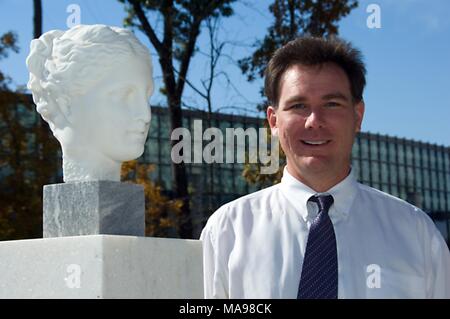 Bust portrait photograph of John P. Anderton, the CDC computer scientist who integrated CDC's presence in the virtual world Second life, posing next to a marble sculpture representing the head of Hygeia, the Greek goddess of health, 2006. Image courtesy CDC/John P. Anderton. () Stock Photo