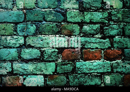 Brick wall with moss growing out of it. multi-colored bricks in the old wall close-up. Background in grunge style Stock Photo