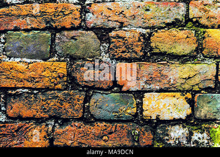 A close-up shot of the old rough brick masonry wall lined with red clumsy brick for backgrounds. multi-colored bricks in the old wall close-up. Backgr Stock Photo