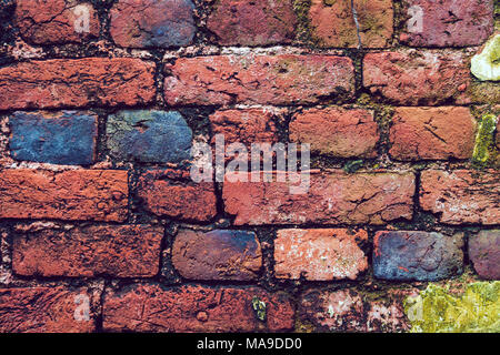 Vintage brick wall background with spotlights on the wall in heart shape. multi-colored bricks in the old wall close-up. Background in grunge style Stock Photo