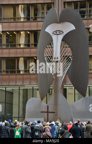 Chicago, Illinois, USA, 30 March 2018: The First Station service is conducted in Daley Plaza under the Picasso sculpture during the Way of the Cross procession through downtown Chicago. The approximate 2-mile procession begins at Daley Plaza and concludes at Holy Name Cathedral. Stock Photo