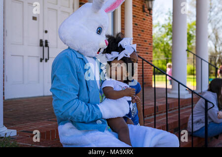 Alabama, USA, 31 Mar 2018. 11-month-old Aniyla Walker, looking at the easter bunny, was not too sure what to think of this large rabbit. Aniyla's older sister, Arya who is six, didn't seem to mind at all. The kids were at the Easter Egg Hunt in Vernon, Alabama with their mother, Aleea. The event was held Saturday, March 31st 2018. Credit: Tim Thompson/Alamy Live News Stock Photo