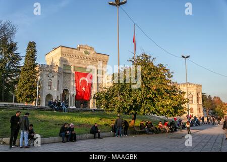 Students resting on the Beyazit Square in front of the gate entrance with the Turkish flag of the Istanbul University, Istanbul, Turkey, November 25, 2017. () Stock Photo