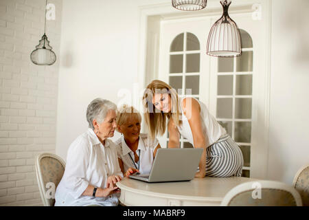 Portrait of happy women of three generations using laptop  in the room at home Stock Photo