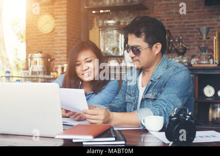Two young business working on their laptop, While sitting in a cafe, Talking serious with work. Business life concept. Stock Photo