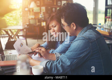 Two young business working on their laptop, While sitting in a cafe, Talking serious with work. Business life concept. Stock Photo