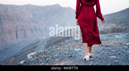 Woman in red dress on a desert mountain top close up Stock Photo