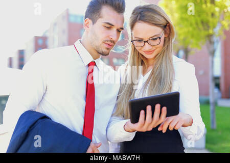 Young ameriacan businesspeople using digital tablet outdoor Stock Photo