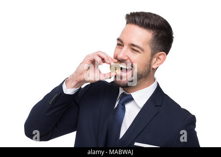 Young caucasian businessman bite into golden bitcoin coin, isolated on white Stock Photo