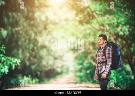 Hipster man hiker holding poles and looking away. Stock Photo