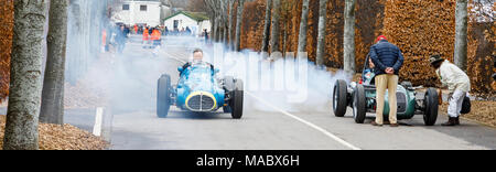 1953 Maserati A6GCM passes a smoking 1959 HWM-Alta 51 of Jarrah Venebles in the paddock at Goodwood 76th Members Meeting, Sussex, UK. Stock Photo