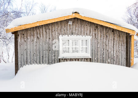 Snow covered cabin in a Sami village in Swedish Lapland Stock Photo