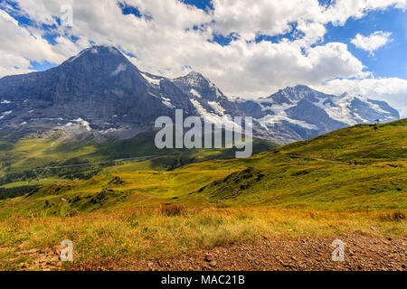 Panoramic view on famous Alpine peaks Eiger, Monch and Jungfrau in summer under cloudy sky. Seen from Mannlichen. Bernese Alps, Switzerland Stock Photo