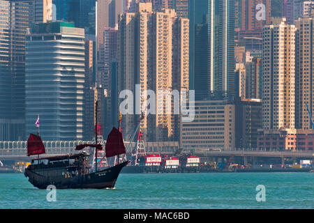 Junk boat and high rises in Victoria Bay, Hong Kong, China Stock Photo