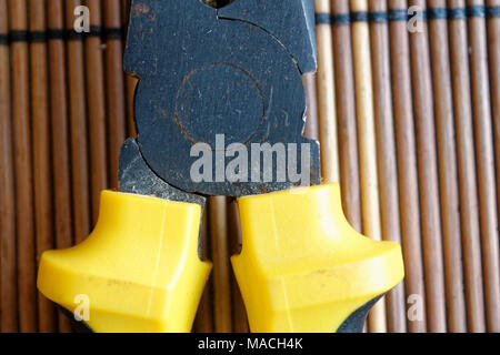 Pliers also known as pointy nose pliers or long nose pliers isolated on wooden background. Stock Photo