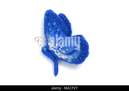 Handmade brooch from felt in the form of a blue butterfly, decorated with beads on a white background Stock Photo