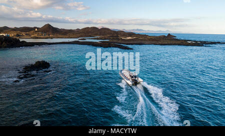 23.12.2017: Boat with tourists on the pier of the island of Lobos, off the coast of Corralejo, on the island of Fuerteventura Stock Photo