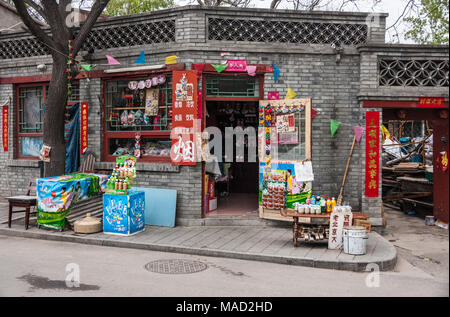 Beijing, China - April 26, 2010: Colorfull corner stone displaying souvenirs, drinks, toys and more aiming tourists. Gray building and some trees. Stock Photo