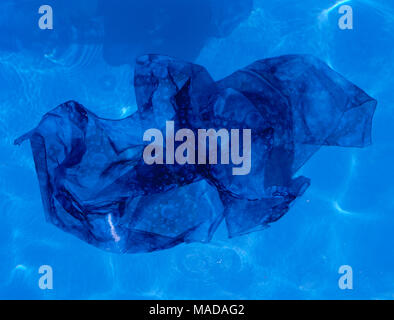 Blue fabric floating in pool Stock Photo