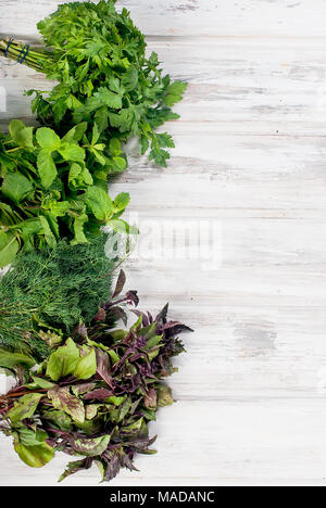 Organic fresh spicy herbs, mint, sprigs of basil, dill, parsley  on the white old wooden table Stock Photo