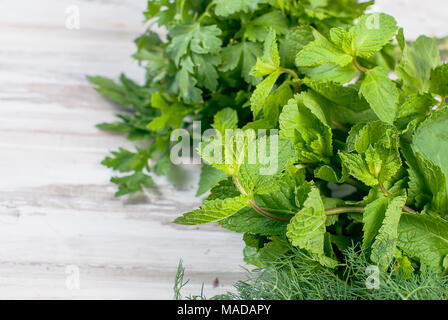 Bunch Organic fresh sprigs of mint on the white old rustic wooden table Stock Photo