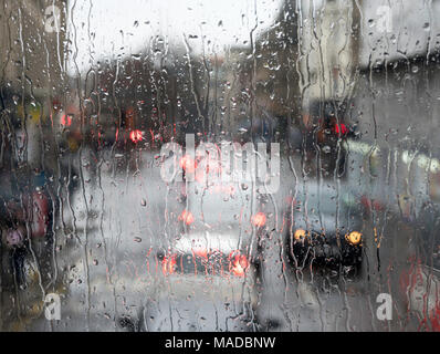 Road traffic seen through heavy rain on window, Newcastle city centre, north east England, UK