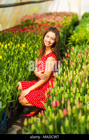 Beautiful young woman in tulips field Stock Photo