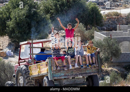 Bilin, Palestine, December 3, 2010: Palestinian boys are sitting on the back of a truck in the village of Bilin, north of Ramallah. Stock Photo