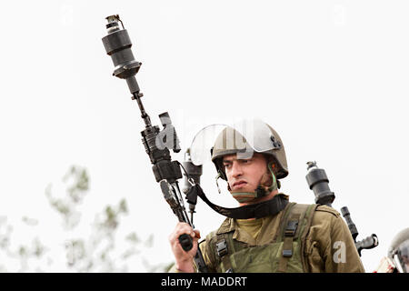 Bilin, Palestine, December 31, 2010: Israel Defence Force soldier is getting ready to shoot tear gas during weekly demonstrations against Palestinian  Stock Photo